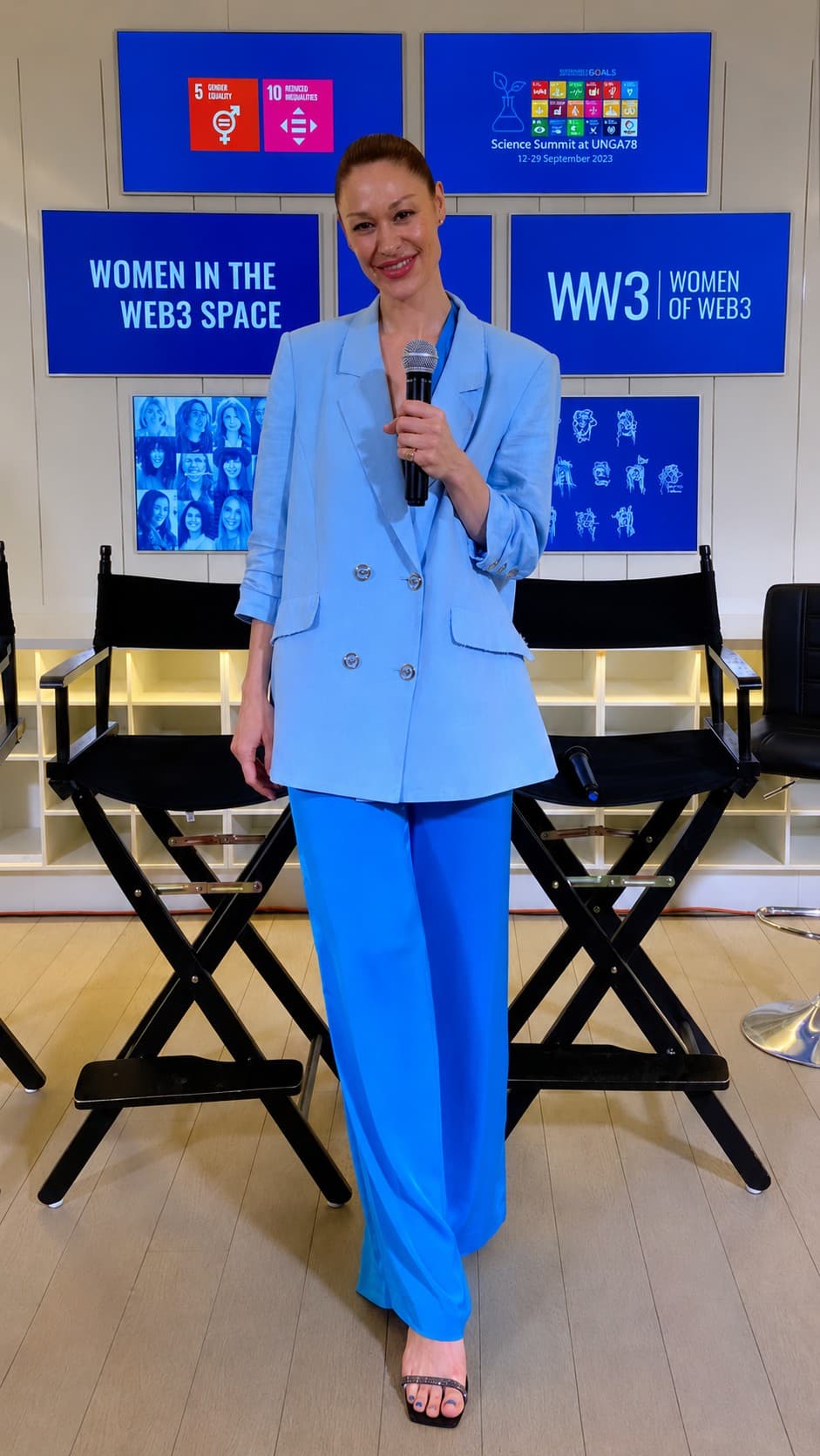 Carley Beck speaking on stage at UNGA78 with a microphone. Behind her, the Science Summit at UNGA78 screen dated 12–29 September 2023, Sustainable Development Goals 5 and 10, and the “Women in the Web3 Space” and “WW3 | Women of Web3” panels